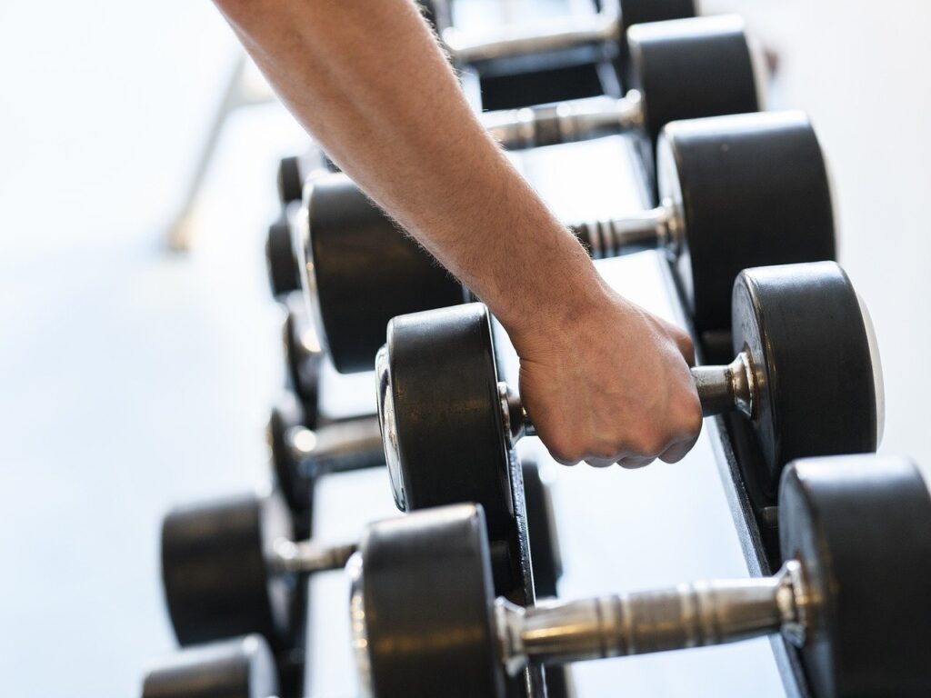 A person lifts a dumbbell in a gym